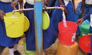 Pupils collect water at a school